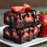 Chocolate covered strawberry brownies stacked on a dessert plate