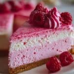 Luxurious pink velvet raspberry cheesecake on a white plate