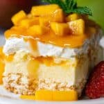 Mango Tres Leches cake topped with whipped cream, mango cubes, and syrup