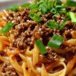 Close-up of Mongolian Ground Beef Noodles with green onions and sesame seeds