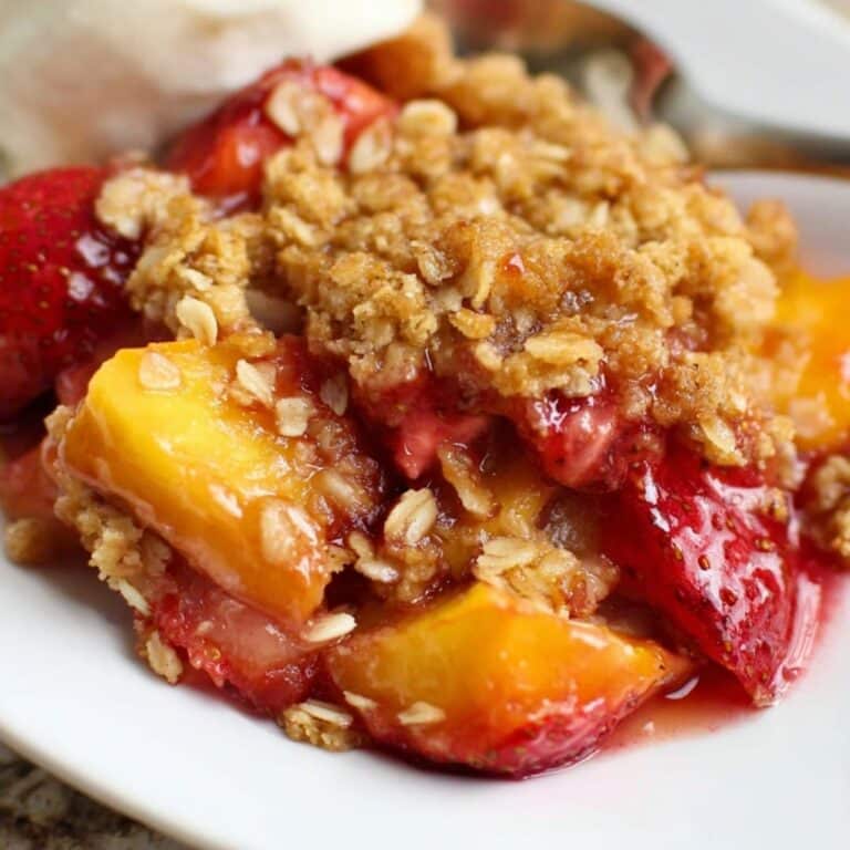 Strawberry peach crisp dessert baked with oats and served in a white dish