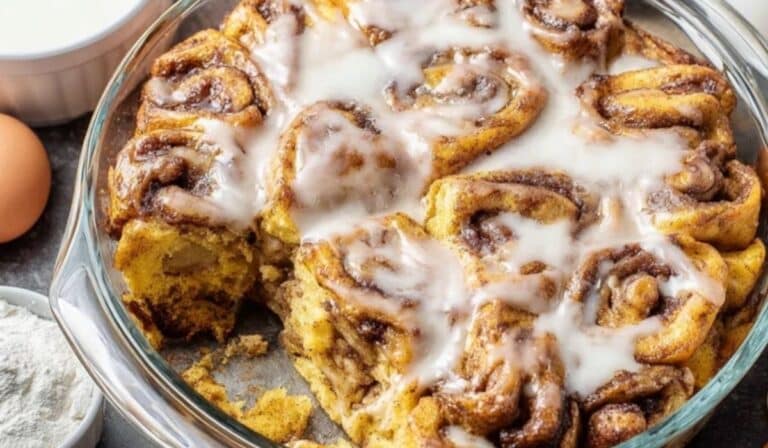 Cinnamon Roll French Toast Casserole baked in a round glass dish with icing on top