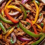 Crockpot Fajitas with chicken, bell peppers, and onions in slow cooker