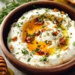 Spicy Ricotta Dip with Hot Honey served in a rustic bowl with herbs and toasted bread