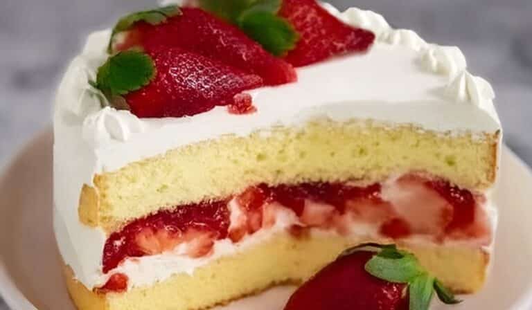 Slice of strawberry cream cake with fresh strawberries and whipped cream filling