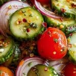 Marinated Cucumbers, Onions, and Tomatoes in a glass bowl