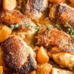 Apple Cider Chicken with Butternut Squash in a cast-iron skillet with caramelized glaze
