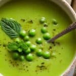 Green Pea Soup in white bowl with mint garnish