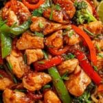 Honey Sriracha Chicken Stir Fry with bell peppers and noodles in black bowl