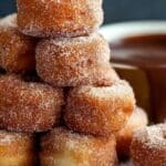Sweet Churro Donut Bites stacked with chocolate dip