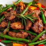 General Tso Pork Stir-Fry with green beans and carrots in a white bowl