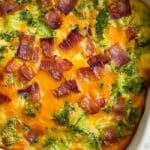 Broccoli Cheddar Egg Bake with Turkey Bacon in a white casserole dish, freshly baked