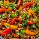 Ground Turkey and Peppers in a black bowl with colorful bell peppers