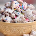 Birthday Cake Puppy Chow Recipe in a yellow bowl topped with rainbow sprinkles