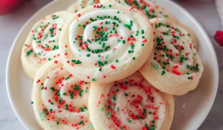 Crumbl Christmas Sugar Cookies with frosting and sprinkles on white plate