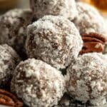 Old Fashioned Bourbon Balls stacked on a plate with pecans