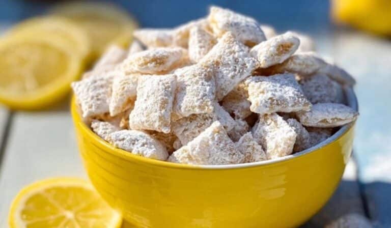 Zesty Lemonade Puppy Chow Snack in bowl with lemon slices
