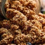 Granola clusters served in a mason jar on a rustic breakfast table