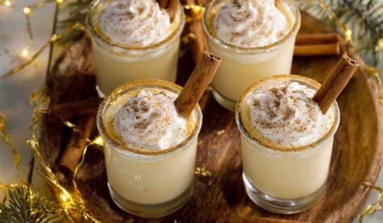Featured Eggnog Shots on a wooden tray with festive garnish