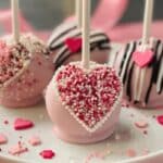Valentine's Day Oreo Pops styled on a white plate with pink background