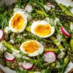 Asparagus and egg spring bowl with quinoa, peas, radishes, and lemon yogurt sauce