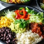 Black bean burrito bowl batch cook in meal prep containers with rice, beans, peppers, and avocado
