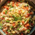 Budget fried rice with egg and veg in a skillet with colorful vegetables