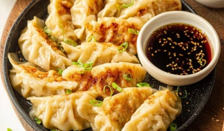 Chicken and cabbage dumplings with golden crisp bottoms in a skillet