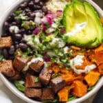 Chipotle steak and sweet potato bowls with avocado, beans, and chipotle yogurt sauce.