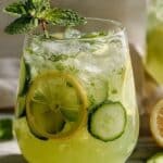 Cucumber mint lemonade in a pitcher with lemon slices and mint