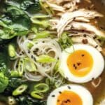 Gut-healing bone broth ramen with noodles, egg, chicken, and greens in a ceramic bowl