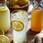 Homemade prebiotic ginger soda poured over ice with lemon and fresh ginger