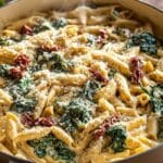 One-pot creamy tuscan pasta in a skillet with spinach and sun-dried tomatoes