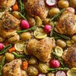 Sheet-pan Easter chicken thighs with asparagus, potatoes, and lemon on a pan